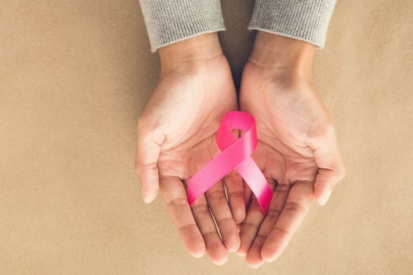 Ženske ruke drže ružičastu vrpcu, simbol borbe protiv raka dojke