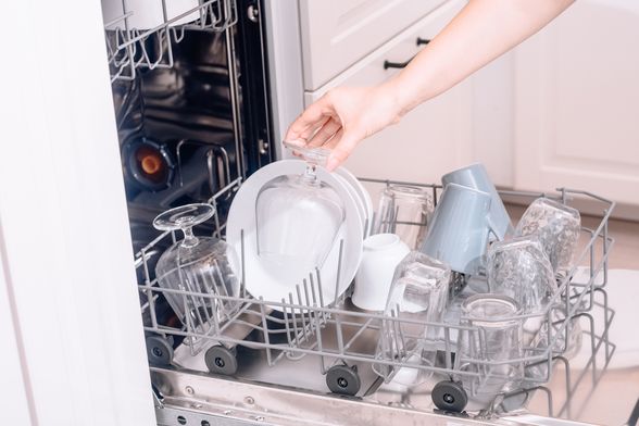 Žena puni perilicu posuđa