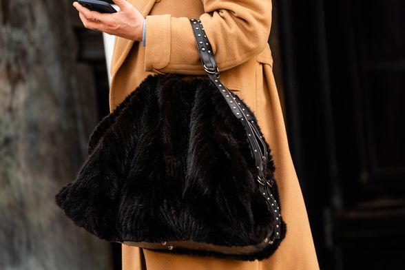 Žena nosi krznenu torbu