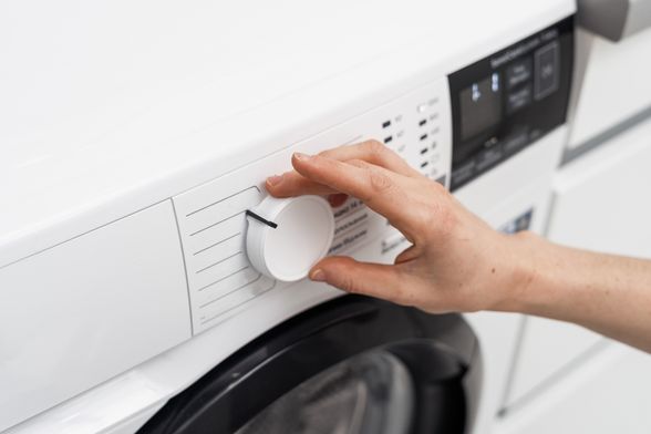 Žena namješta perilicu rublja