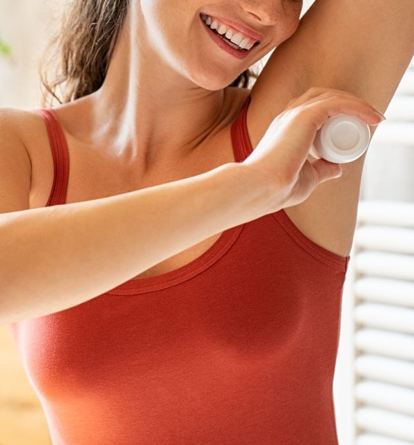 Žena nanosi dezodorans
