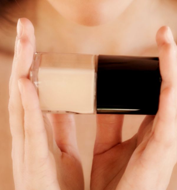 Žena drži bočicu tekućeg pudera