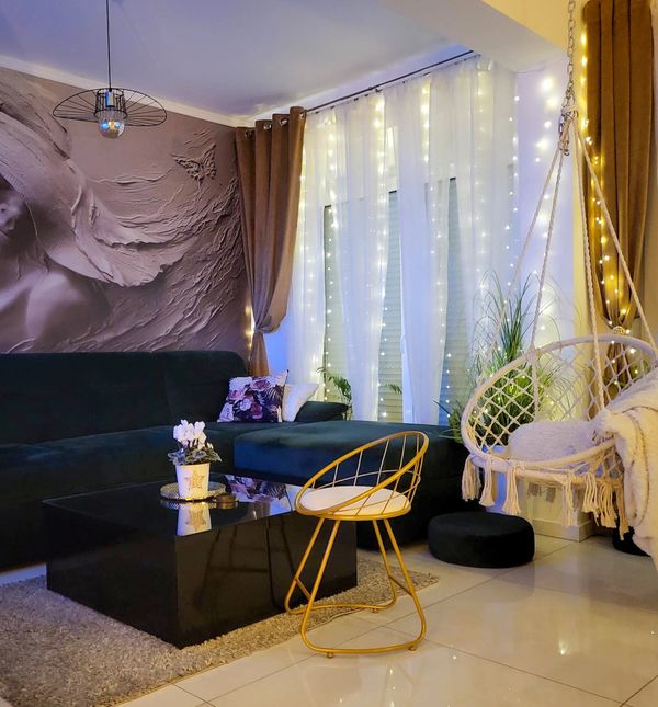 Zid dnevnog boravka krasi impresivna tapeta žene sa šeširom, a savršeno se uklopila i ljuljačka za sjedenje