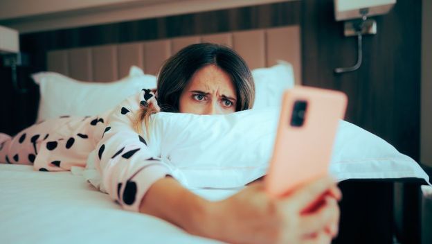 Djevojka zabrinuto gleda u mobitel