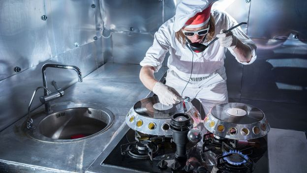 Kuhar i DJ u jednoj osobi kako kuha i pušta glazbu