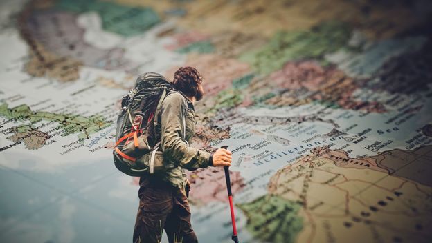 Muškarac koji putuje svijetom i karta svijeta
