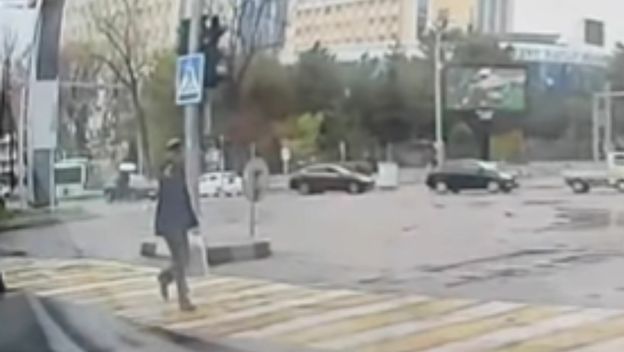 Starac koji prelazi cestu s pištoljem u ruci