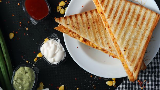sendvič prerezan na pola na stolu uz umake