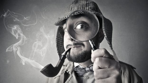 Detektiv s povećalom ispred lica