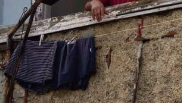 Muškarac na prozoru kako peče roštilj