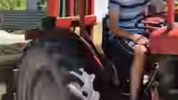 Mladić na traktoru koji prevozi kauč