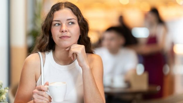 Djevojka sjedi sama u kafiću