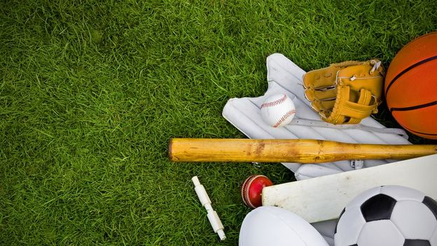 sportski rekviziti iz raznih sportova posloženi na travu