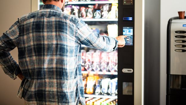 Muškarac koristi automat za hranu i piće