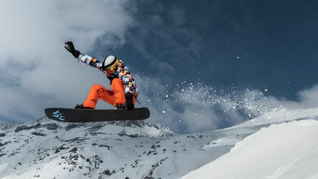 Snowboarder u letu kako izvodi trik