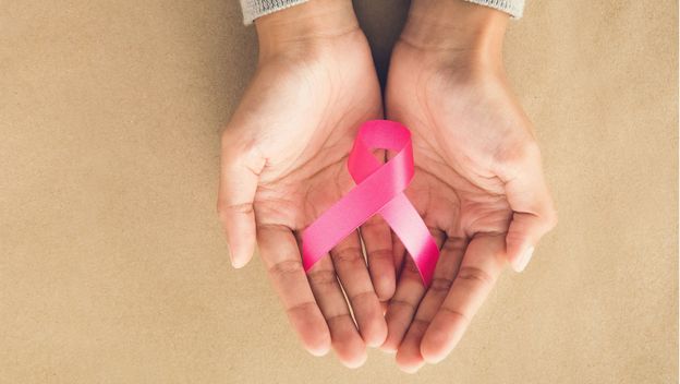 Ženske ruke drže ružičastu vrpcu, simbol borbe protiv raka dojke
