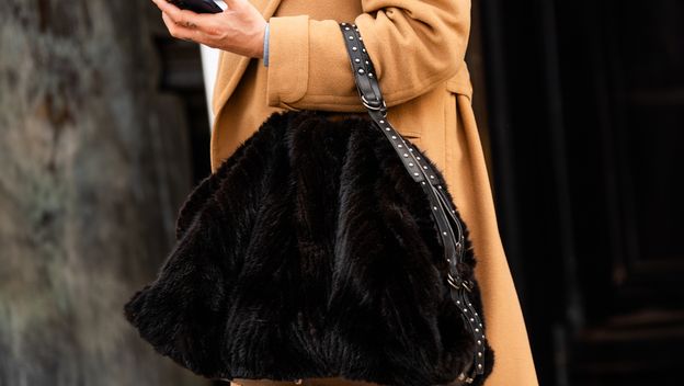 Žena nosi krznenu torbu