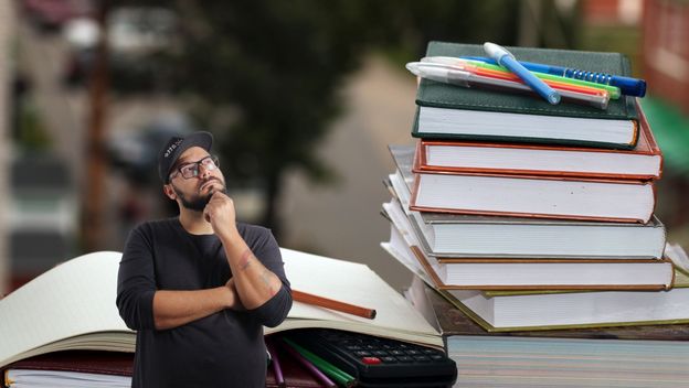 Razne knjige i pomagala u učenju uz muškarca koji razmišlja