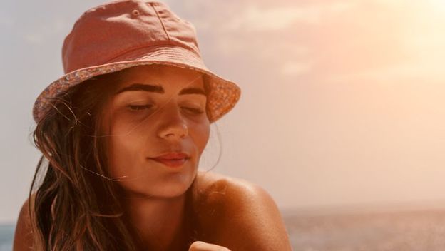 Djevojka sa šeširom se sunča