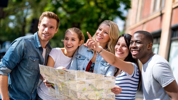 Razni turisti koji gledaju na kartu