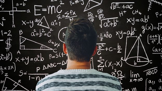 Muškarac kako razmišlja ispred ploče s matematičkim formulama