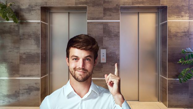 Dizalo u zgradi i muškarac koji pokazuje prema gore