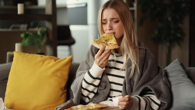 Tužna djevojka jede pizzu