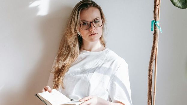 Djevojka s naočalama čita knjigu