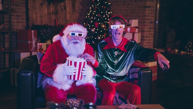Djed Božičnjak i patuljak pomagać gledaju filmove s 3d naočalama i kokicama