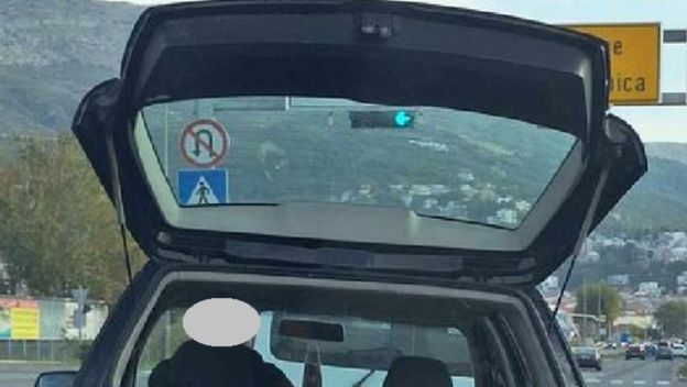 Vozač koji rukom pridržava teret koji prevozi