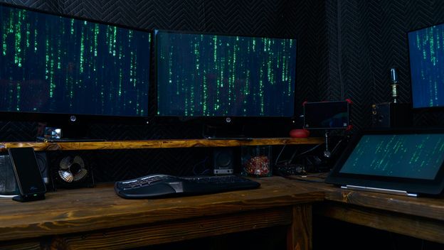 računala na stolu s brojkama kao iz filma Matrix