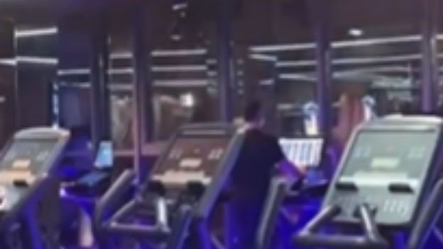 Muškarac u teretani na traci za trčanje