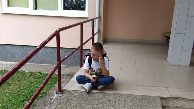 Dječak ispred škole čeka pomoćnika u nastavi (Foto: Facebook)