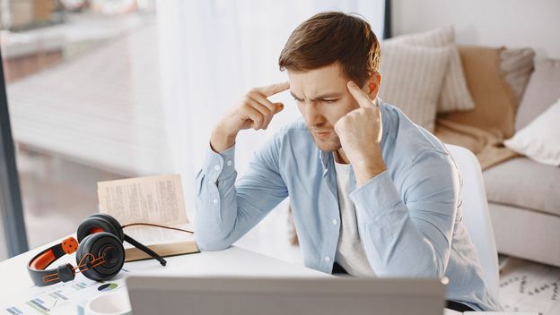 Muškarac za računalom kako razmišlja