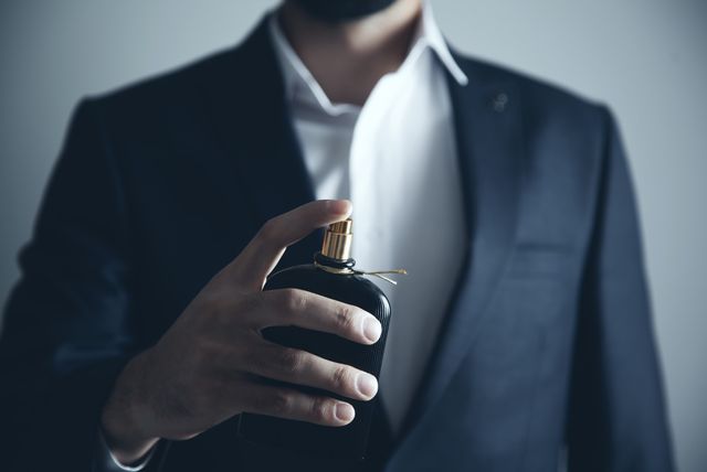 Muškarac stavlja parfem