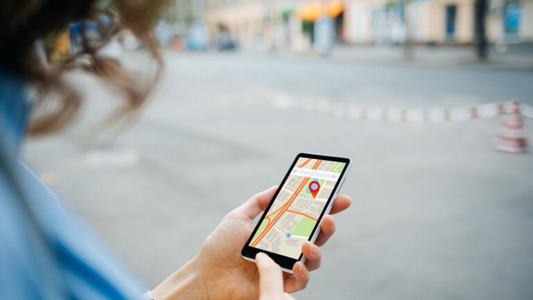 Žena koristi aplikaciju karata na mobitelu za navigaciju, ilustracija