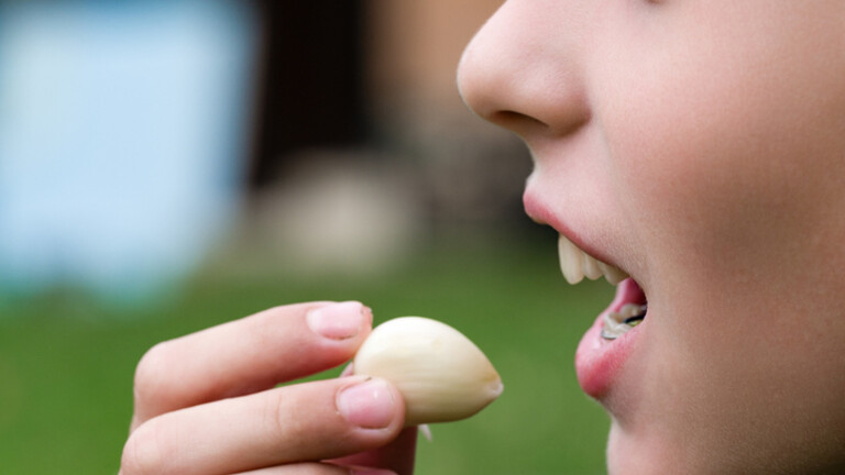 Djevojka jede češnjak