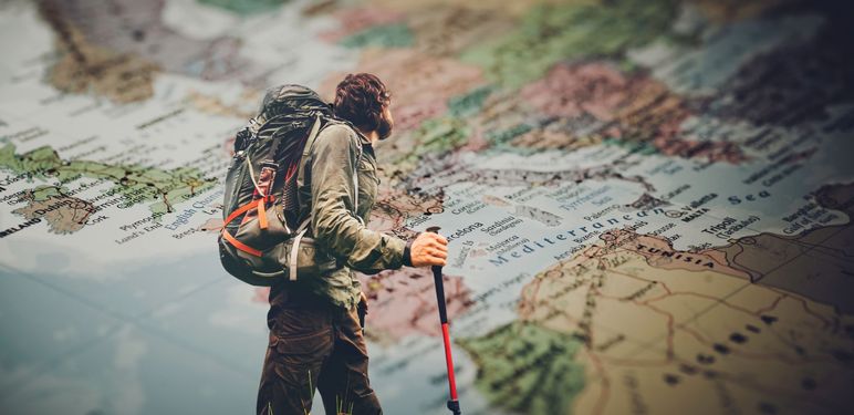 Muškarac koji putuje svijetom i karta svijeta