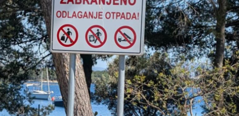 Deponij ispod znaka za zabranu odlaganja otpada