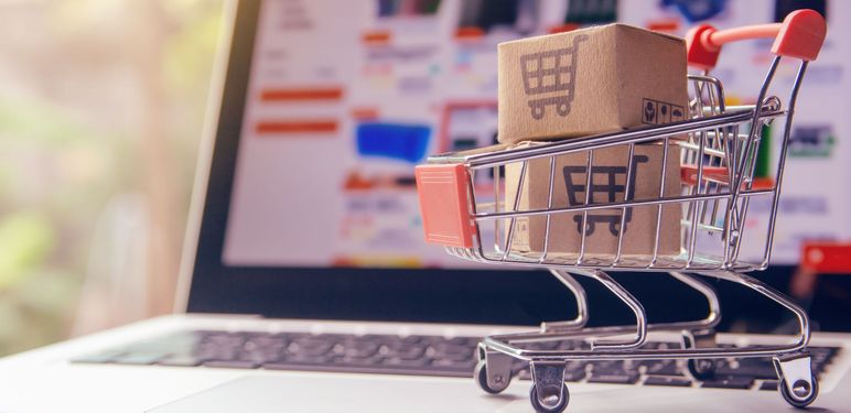 Kolica za kupnju puna paketa i laptop s otvorenom stranicom za kupnju