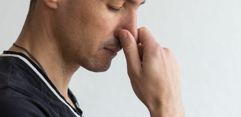 Muškarac koji se drži za nos