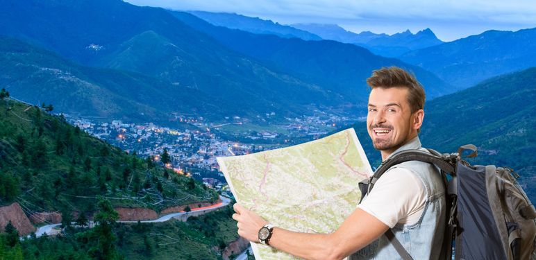 Grad u planinama i turist s ruksakom i kartom