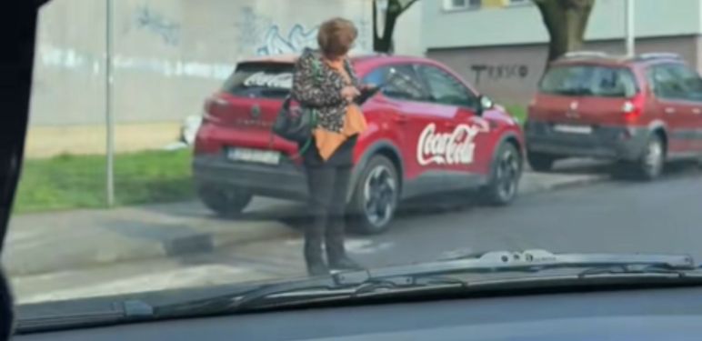 Gospođa na mobitelu nasred pješačkog prijelaza