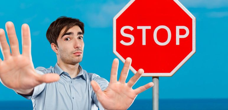 Muškarac koji blokira prolaz i znak stop