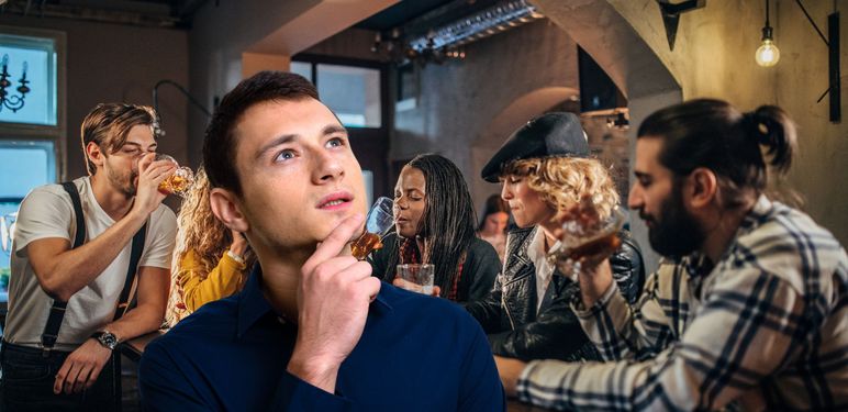 Ekipa koja se druži u Pubu i muškarac koji razmišlja