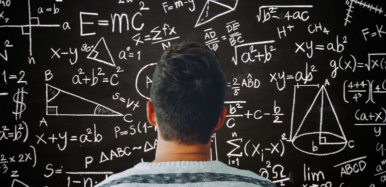 Muškarac kako razmišlja ispred ploče s matematičkim formulama