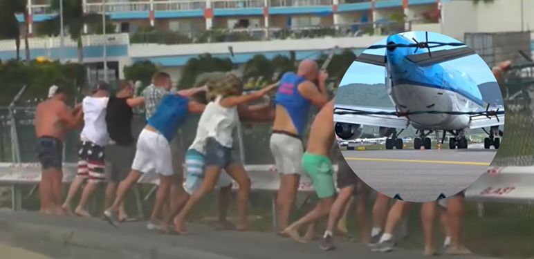 Mlažnjak pri polijetanju i turisti koji se drže za ogradu