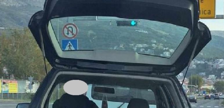 Vozač koji rukom pridržava teret koji prevozi