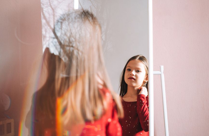 Djevojčica se gleda u ogledalo