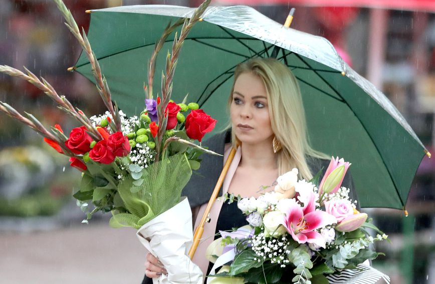 Plavokosa dama iz Zagreba s buketima cvijeća na kišni dan